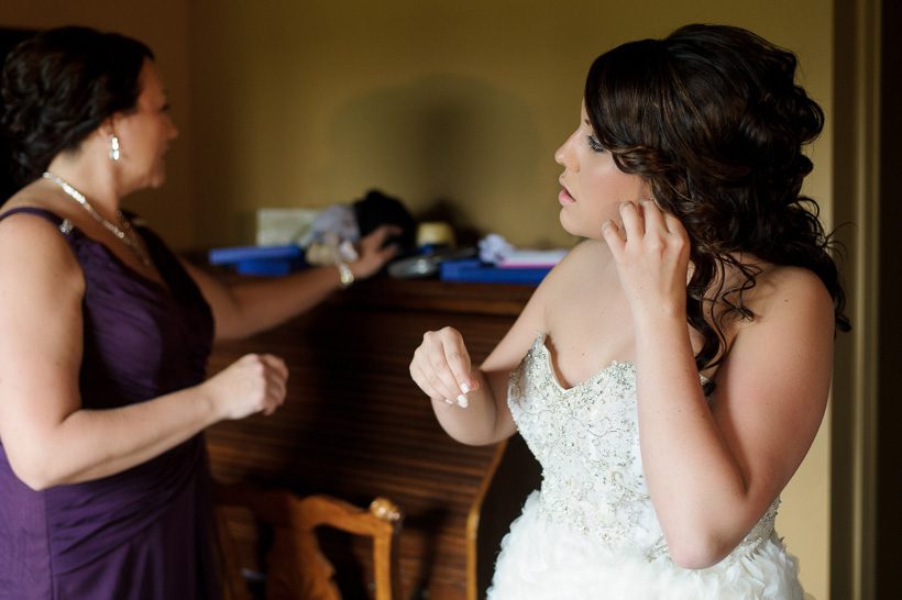 Bride putting on earrings
