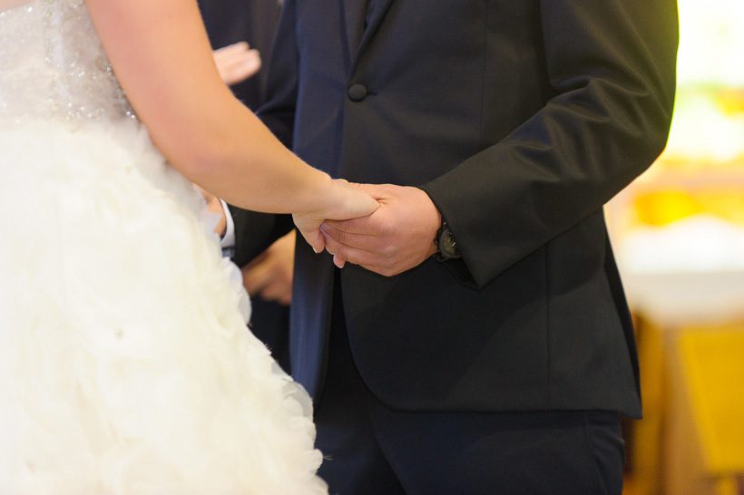 Bride and groom holding hand in church