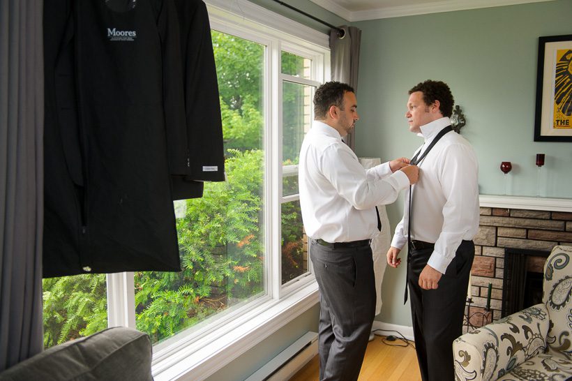 Groom putting on tie