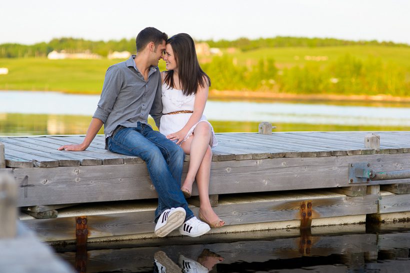 Couple sitting next to water on warf