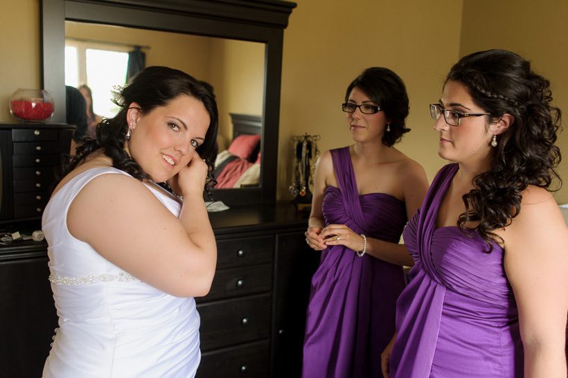 Bride putting on earrings