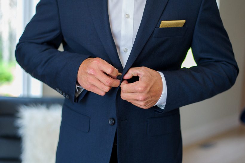 Groom putting on suit