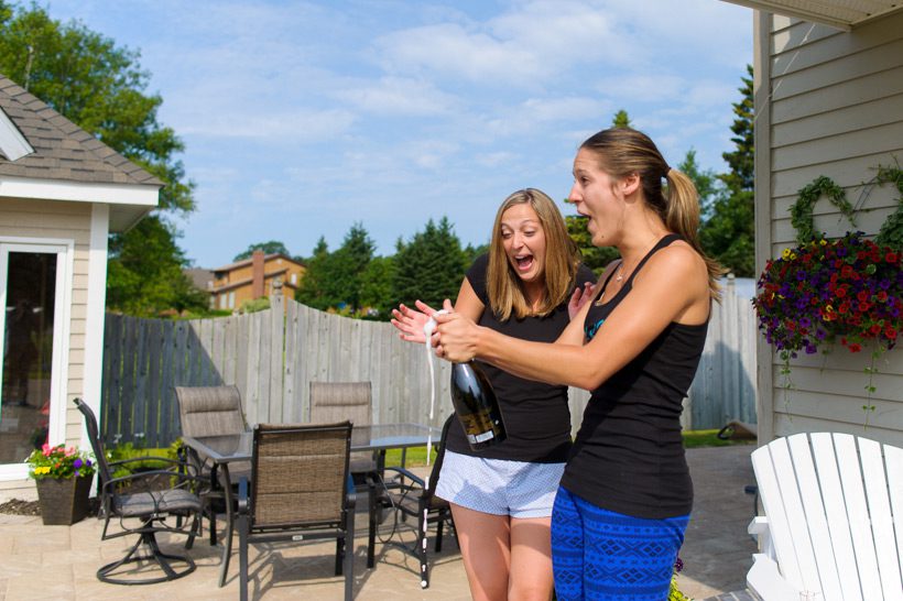 Bride opening champagne bottle