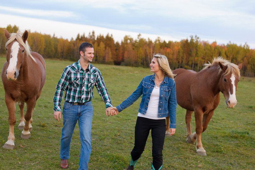 Couple walking with two horses