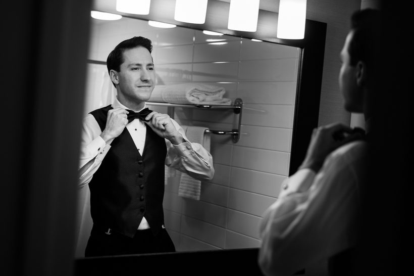 groom arranging bow tie