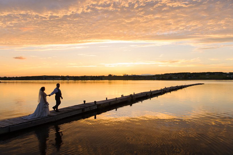 Bride and groom on docks at sunset in Bouctouche