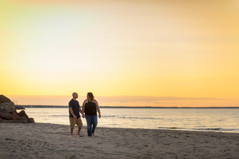 Couple walking on beach at sunset