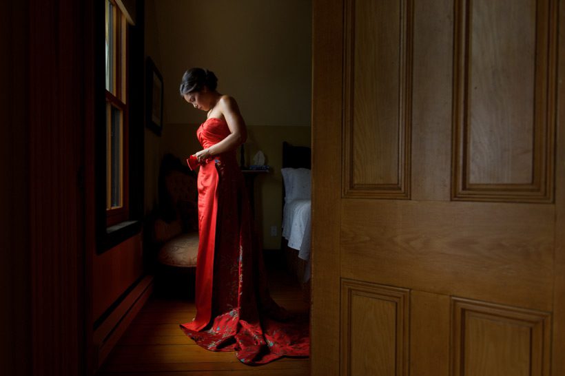 Bride putting on red dress