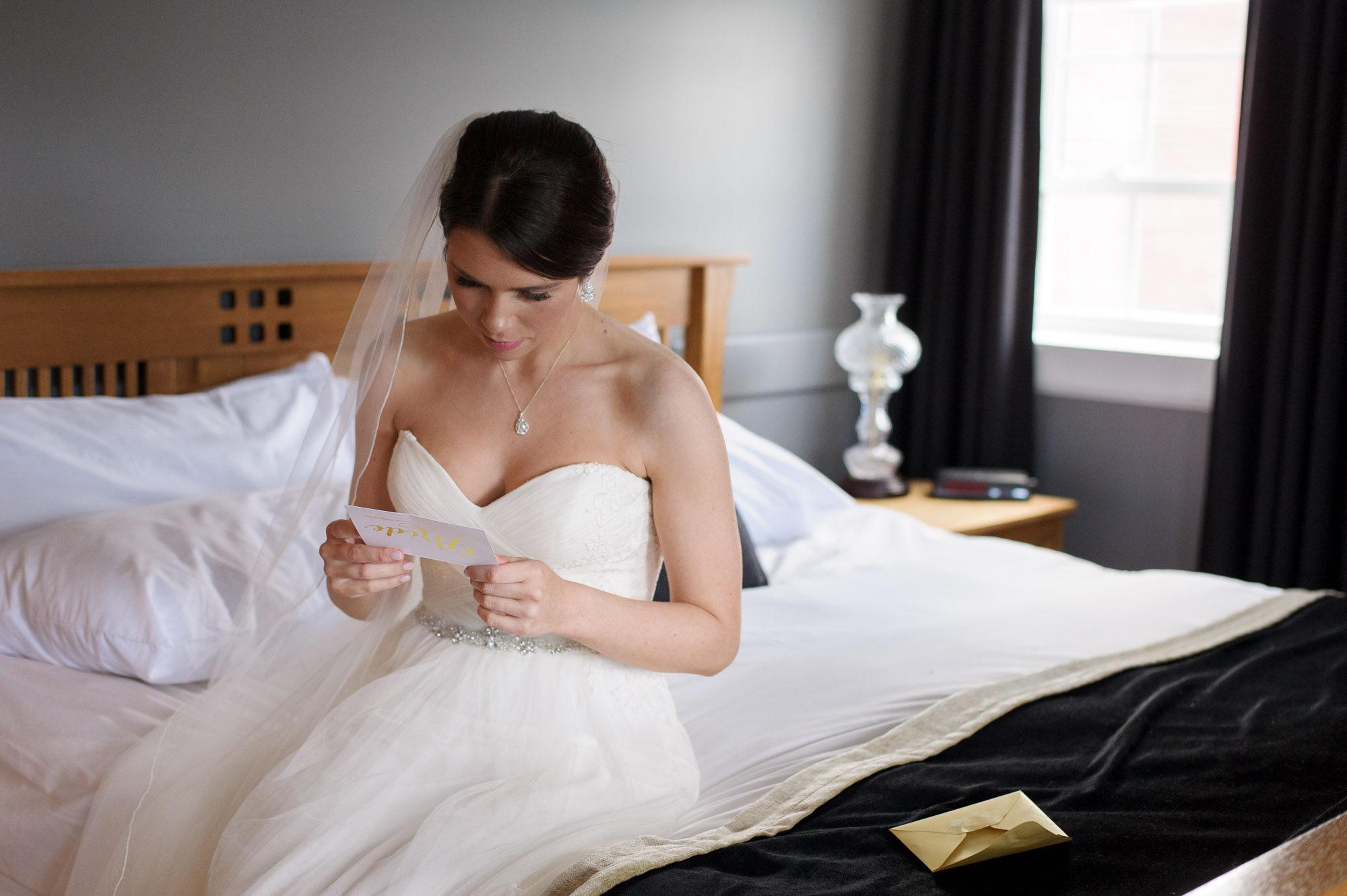 Bride on bed reading letter from groom