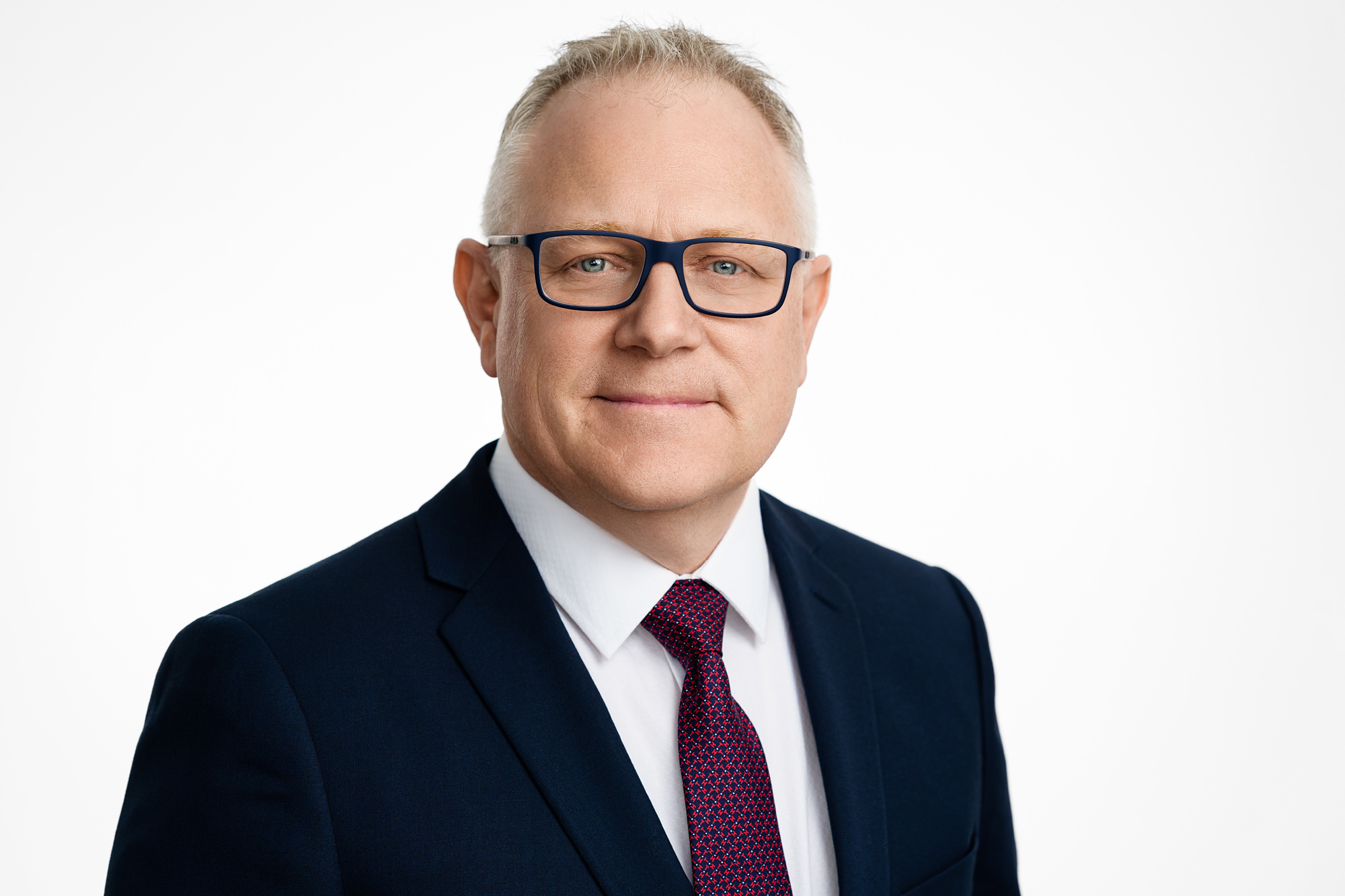 Corporate headshot of businessman and politician on a white background.