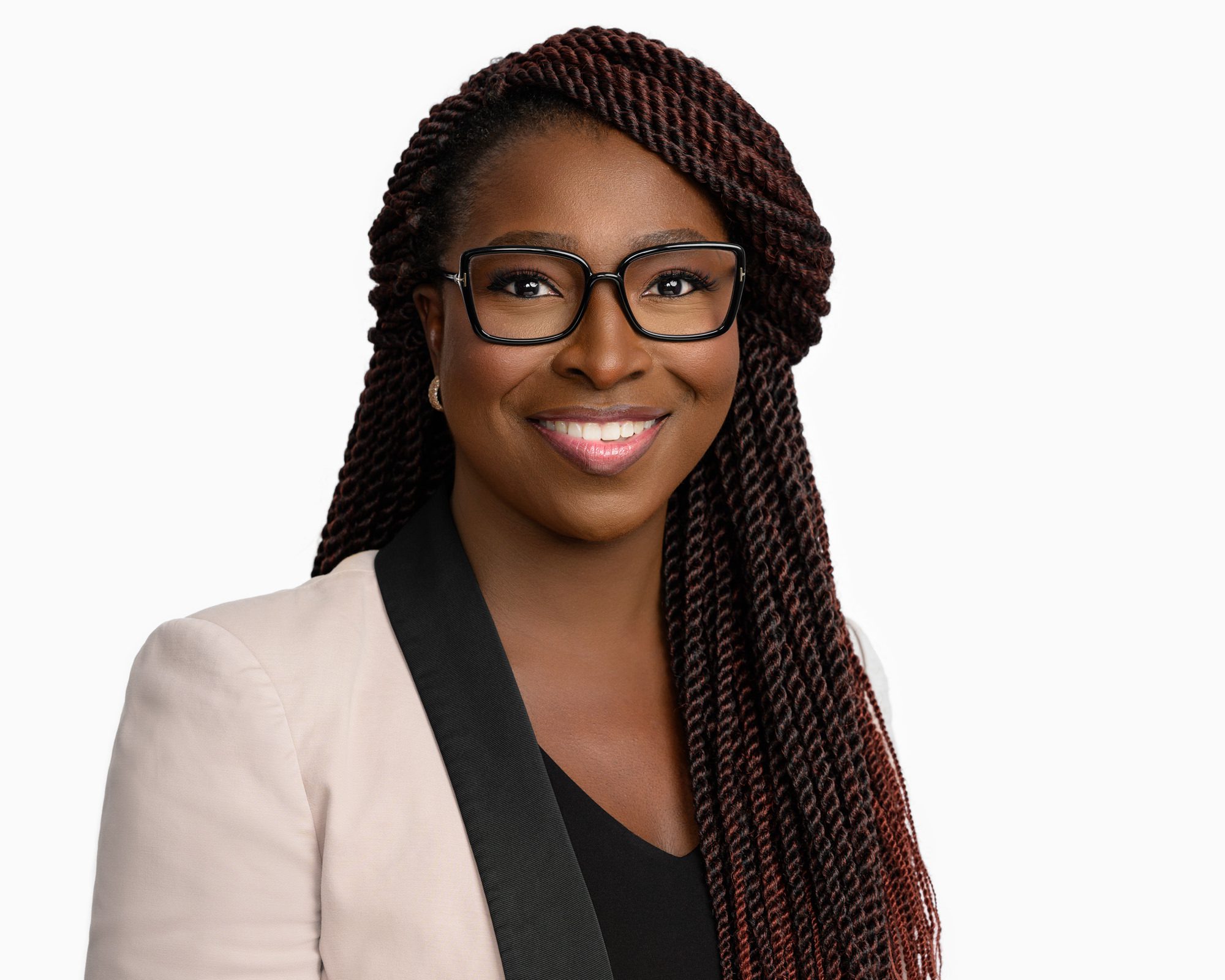 Business headshot of a woman wearing glasses and a light pink blazer.